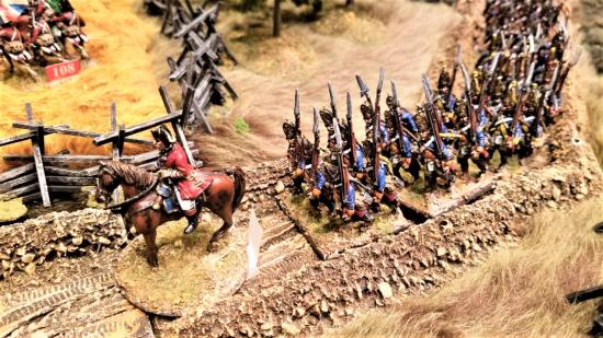 Photo of napoleonic soldier miniatures on a tabletop road at a Historicon convention