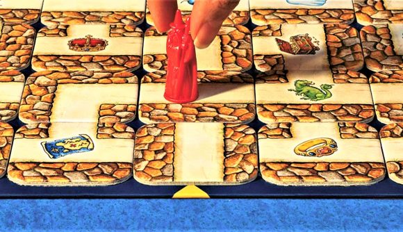 photo of someone moving a game piece on the tile board in Labyrinth board game