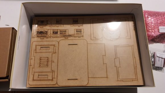 Bolt Action Pegasus Bridge review - photo showing the laser cut wood parts for the bridge model, removed from their box