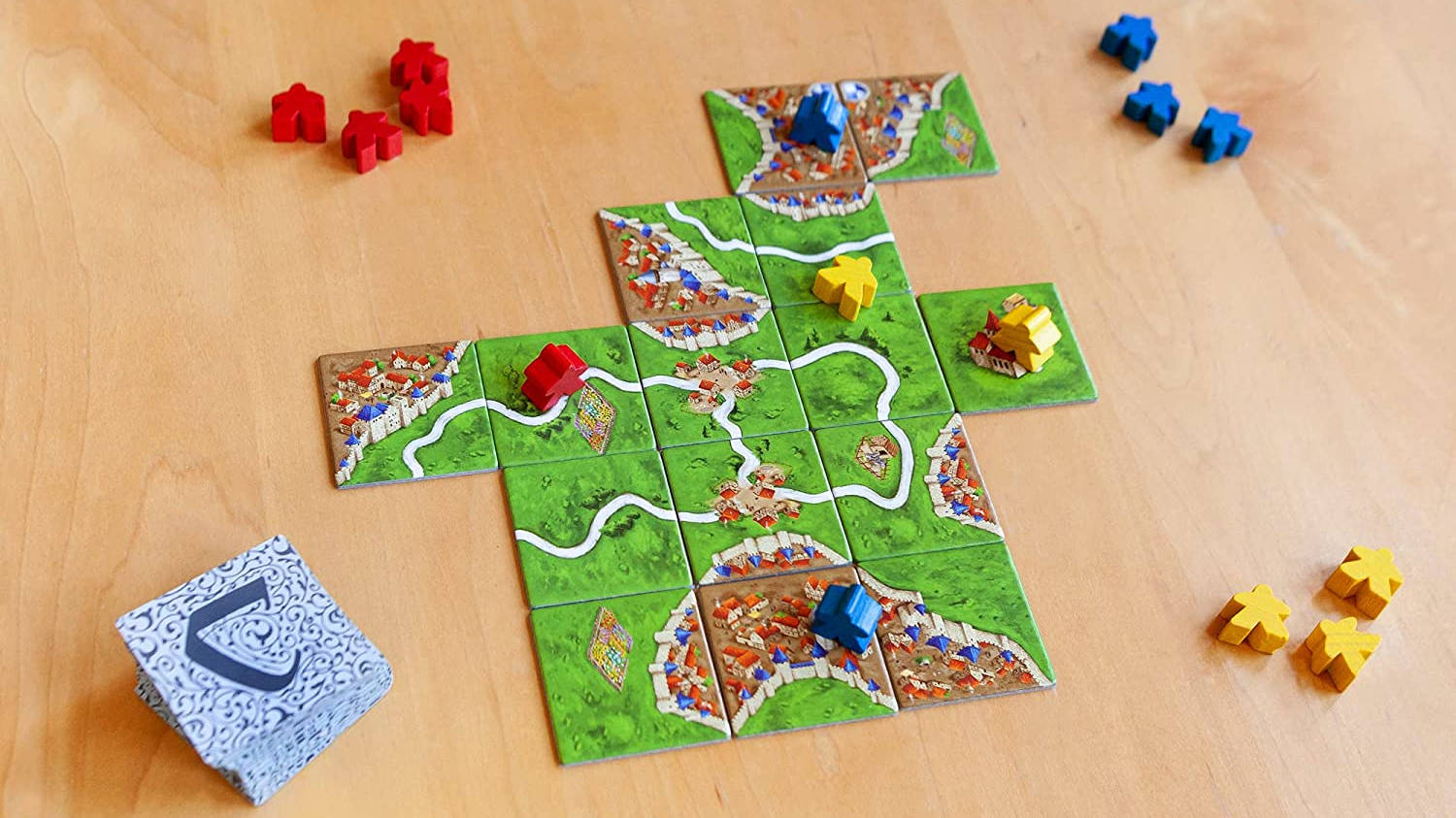 Fun board games Carcassonne tiles and meeple on a table