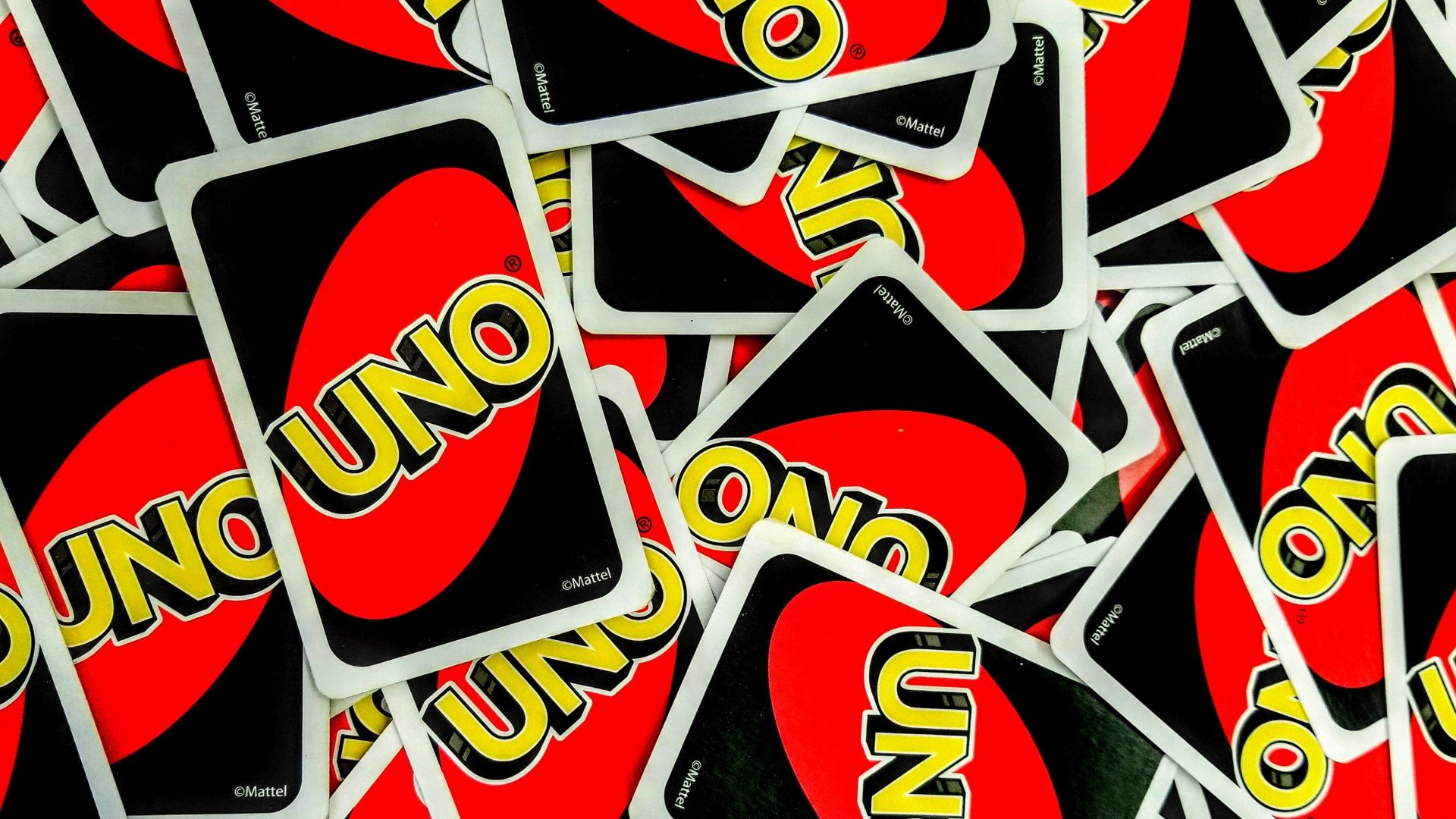 Drinking card games a bunch of Uno cards laid on top of one another, credit to Unsplash Third Serving