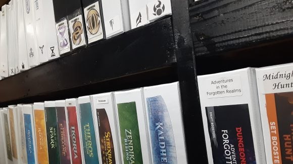 Magic the Gathering all commander decks. A row of binders labelled after each MTG set.