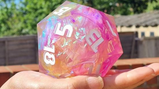 Dnd Giant Dice. A giant pink Dnd dice D20 balanced on someone's palm.