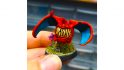 Warhammer 40k squig Pokemon - a squig mini painted to look like Charizard, a red dragon Pokemon