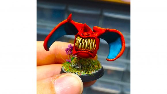 Warhammer 40k squig Pokemon - a squig mini painted to look like Charizard, a red dragon Pokemon
