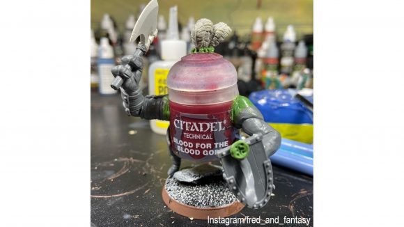 Warhammer 40k paint pot challenge - A pot of red 'Blood for the Blood God' paint, customised to have arms and legs, holding an axe