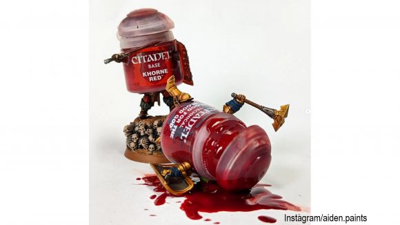 Warhammer paint pot challenge - two pots of red paint fighting, with one of them lying, spilled, on its back