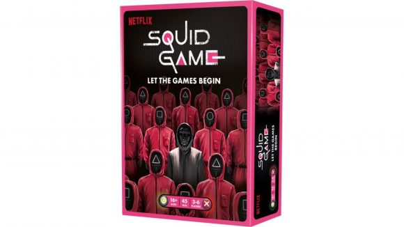 The box for the Squid Game board game, showing the Netflix show's masked characters in pink hoodies surrounding a person in a black mask and hoodie