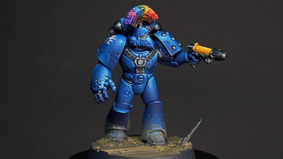 Warhammer 40k fabulous marines pride 2022 - a blue armoured space marine with a rainbow mohawk.