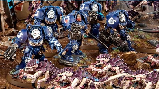 Warhammer 40k 10th edition starter set models - heavily armored Terminators attack a swarm of Tyranid hormagaunts