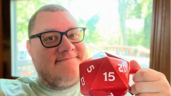 DnD roll for sandwich - a man holding a big red mug in the shape of a D20.