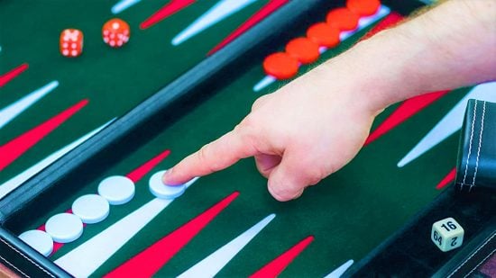 How to play Backgammon - a hand points to a white checker on a green backgammon board with red and white points