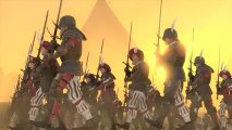 Total War Warhammer 3 - empire greatsword troops marching through a desert with a pyramid in the background.