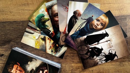 Dixit board game - a fan of cards with surreal, dark artwork