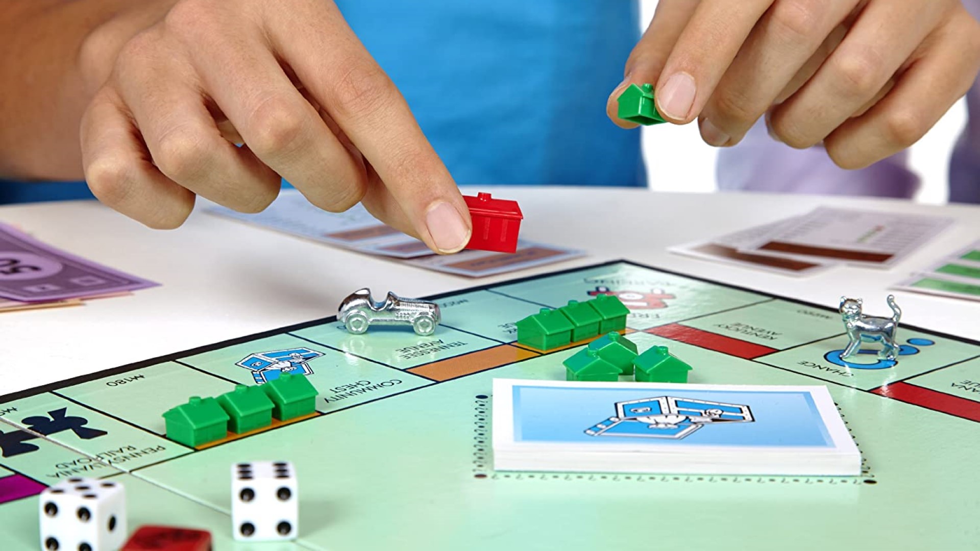 Monopoly - players placing houses and hotels onto a monopoly board
