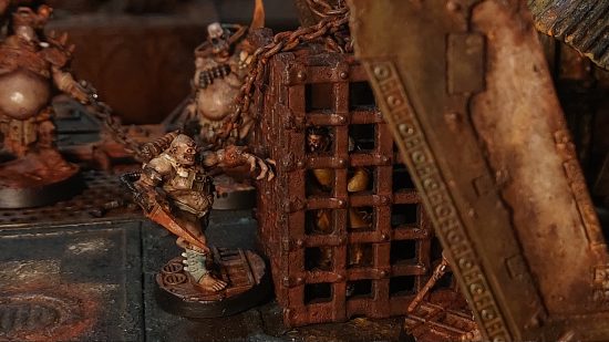 Warhammer 40k Necromunda: photo from Sumphulk of a diorama by Steve Brice, with the mutant war pigs gang tormenting a captive in a rusted iron cage
