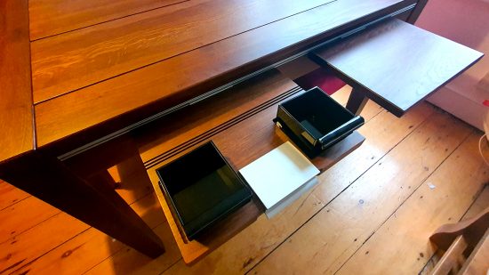 Best gaming tables guide - GeekNSon Megan - author's photo of the flip desk and acrylic bin accessories