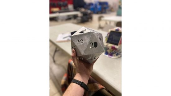 DnD dice - a giant metal d20 in its maker's hand