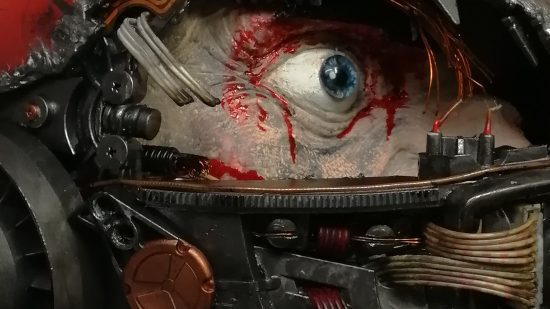 Warhammer 40k Space Marine helmet sculpted by Florian Kschonek - closeup on a human eye behind broken metal interior components of a helmet