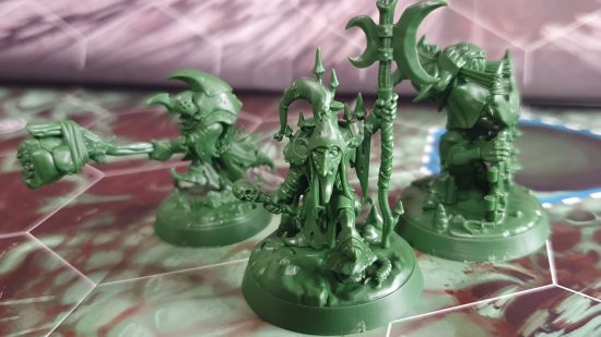 Warhammer Underworlds Grinkraks Looncourt review - close up photograph of three green plastic miniatures, all goblins, one wielding a stick with a small animal tied to it, another wearing a large hat and carrying a moon-shaped halberd