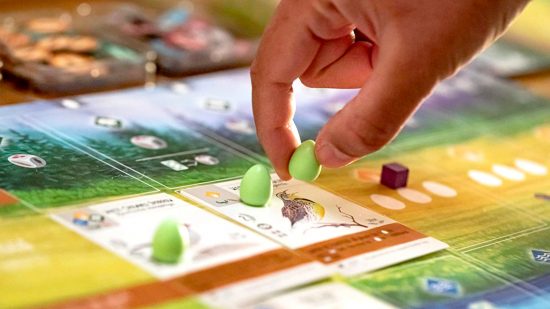 Board games for adults guide - publisher photo showing a player placing an egg token in the Wingspan board game about birds