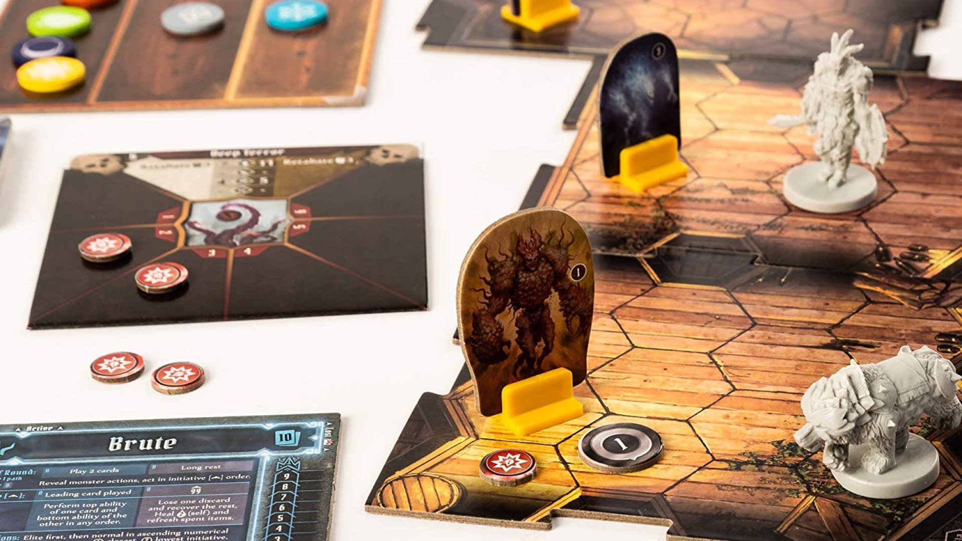 Gloomhaven review - character minis and enemy standees on dungeon board, with various cards and tokens on the side