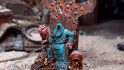 Dark Brexit minis free to EU citizens -a sinister hooded lord sits in a rusted chair, holding a joint of gammon, surrounded by coins and guns, sculpted, painted, and photographed by Curtis Fell of Ramshackle Games
