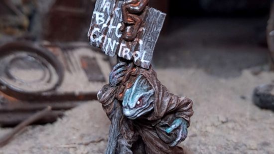Dark Brexit minis free to EU citizens - a fishman mutant in a robe holding a sign that says "Take back control", sculpted, painted, and photographed by Curtis Fell of Ramshackle Games