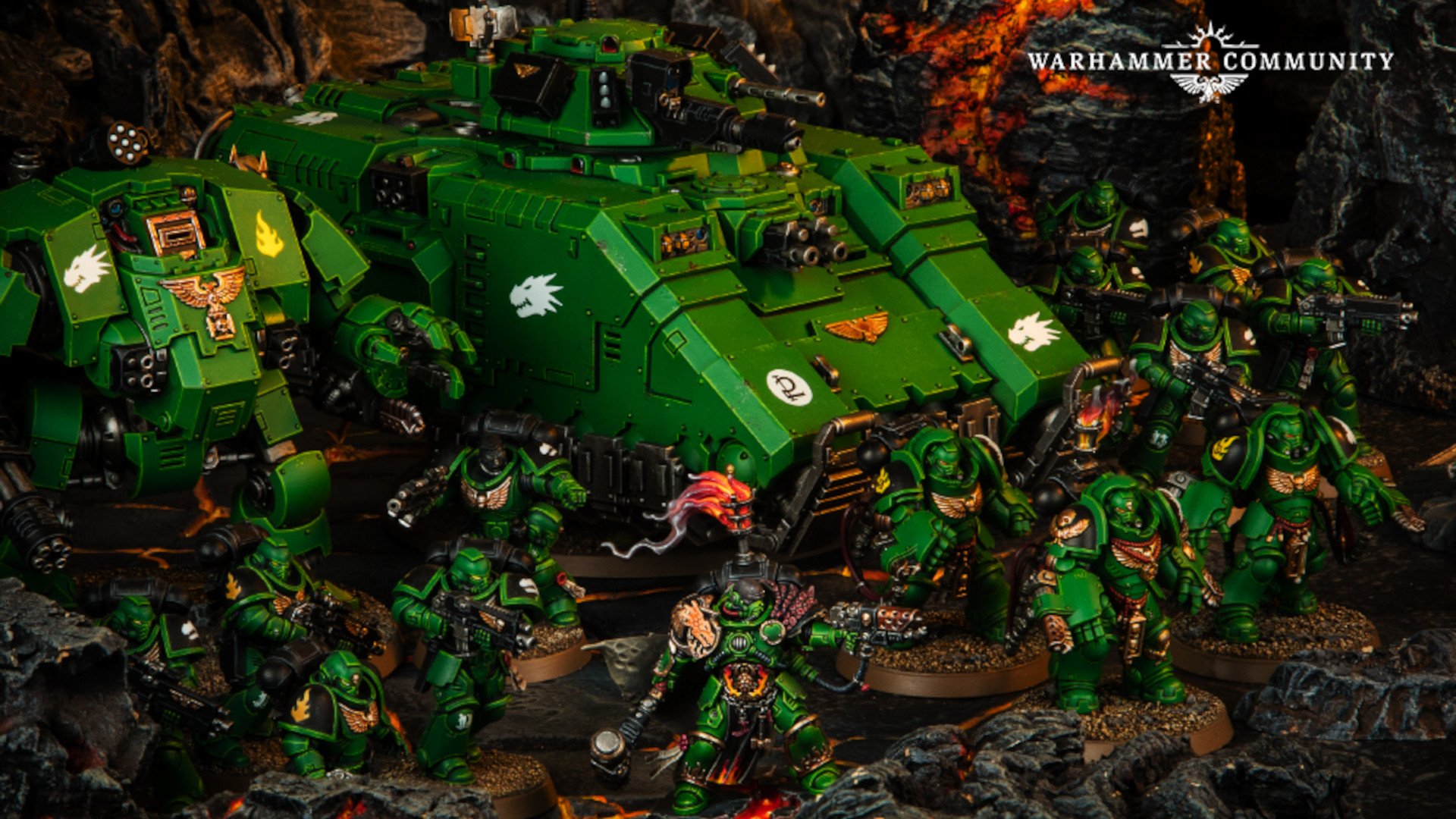 Warhammer 40k Salamanders - diorama photograph by Games Workshop, an army of Primaris Salamanders space marines in Green armour advance in front of their vehicles