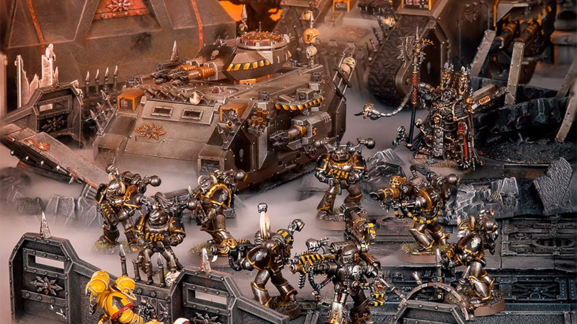 Iron Warriors Chaos Space Marines army advances - diorama photograph by Games Workshop, silver armoured Space Marines advance alongside tank support into enemy territory