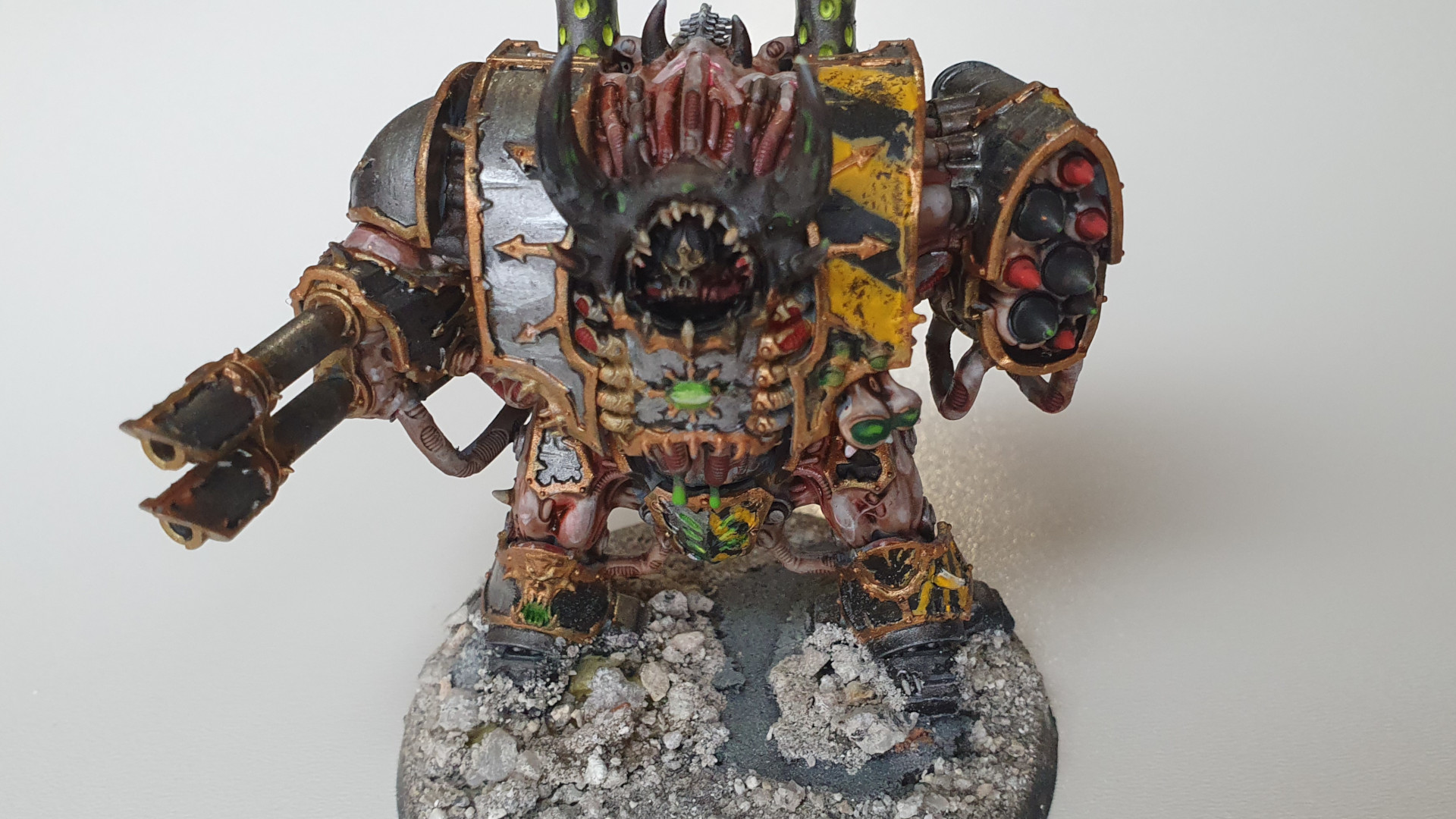 Iron Warriors Helbrute - a warp mutated walker vehicle with exposed flesh, armour silver with gold trim and black and yellow chevrons, with a missile launcher and twin lascannon