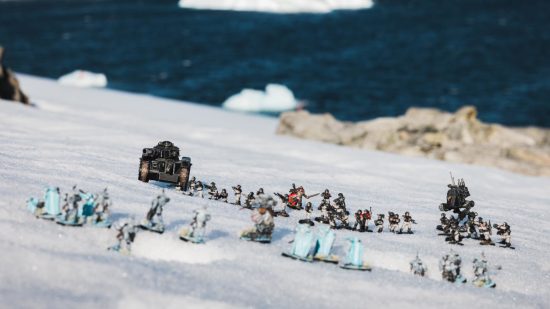 Warhammer 40k competitive 40k in Antarctica - against a backdrop of dark blue ocean, drifting ice, and a field of snow, an army of Imperial guard and Space Marine models face off