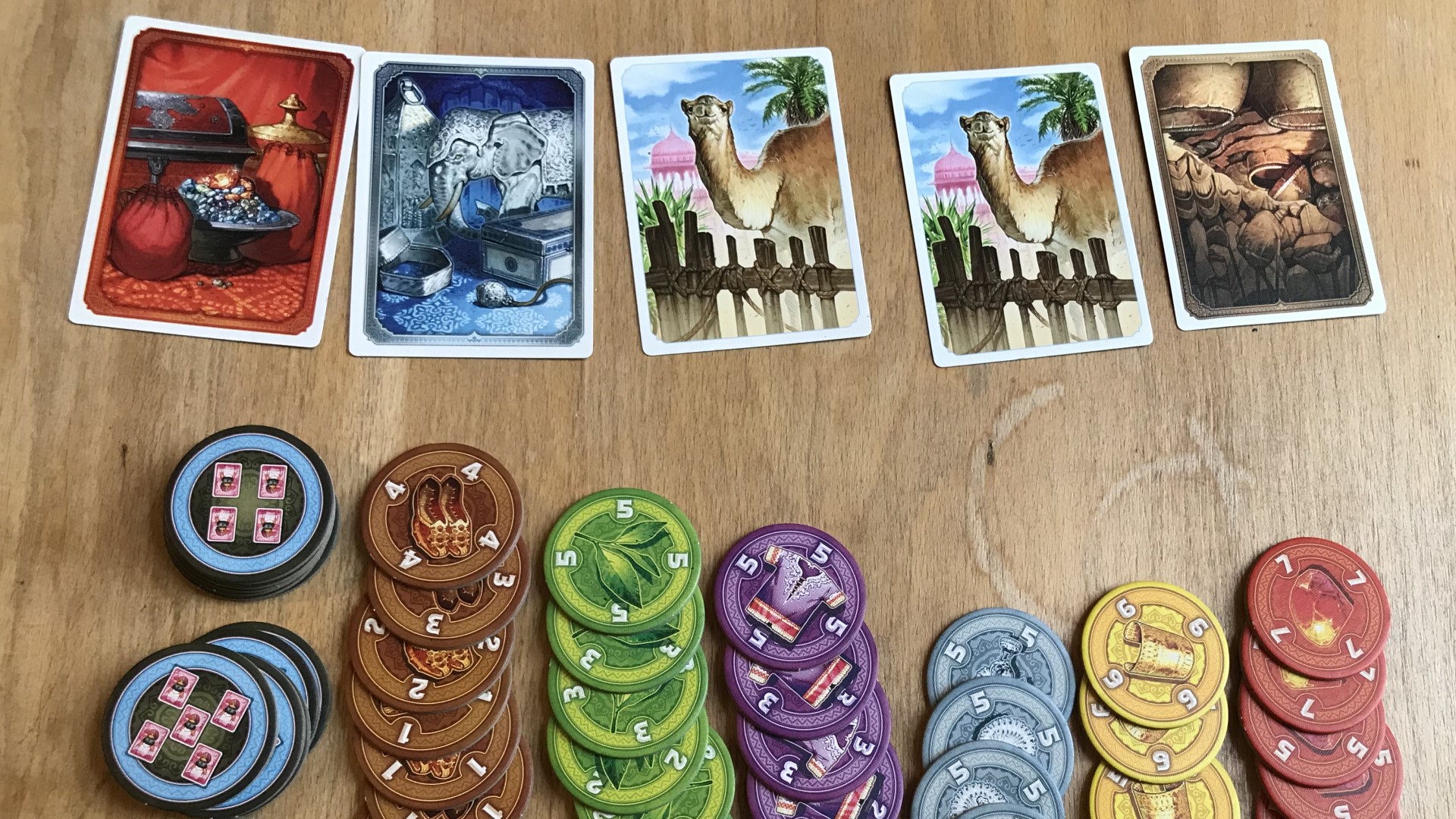 Jaipur board game - five cards showing goods and stacks of goods tokens