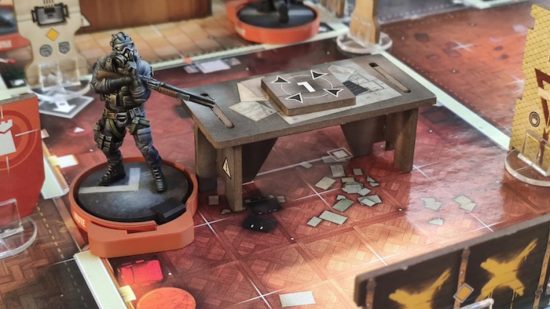 Rainbow Six Siege the board game image of gameplay showing an operator peering over a table