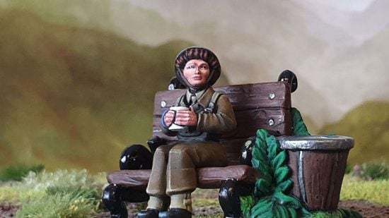 Female miniature by Bad Squiddo games - model of an Auxiliary Territorial Service servicewoman sitting on a park bench.