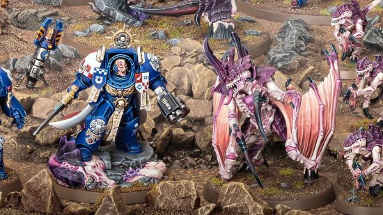 Interview with Warhammer 40k studio manager Stuart Black about Warhammer 40k 10th edition - product photo by Games Workshop of a Space Marine captain in heavy terminator armor facing off against a winged Tyranid prime