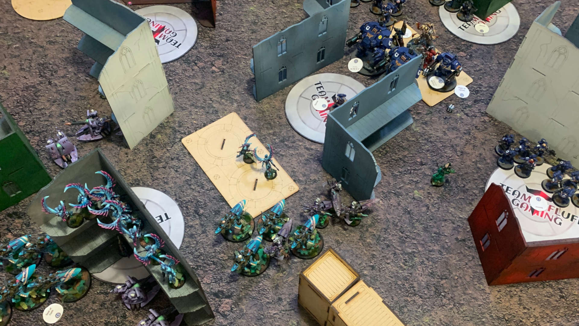 Warhammer 40k tournament organiser explains problems in 10th edition for competitive play - a tournament game in progress, forces jockey for position around ruins
