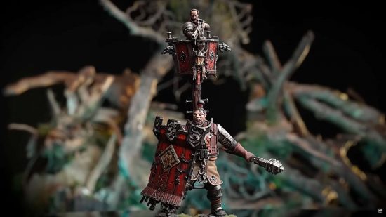 Warhammer Age of Sigmar ogre, the Fusil Major on Ogor Warhulk, an Ogre in leather armor carrying a huge red tower shield and supporting a crows-nest and gunner from his back, miniature by Games Workshop