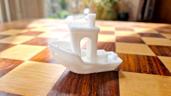 How to 3D print miniatures guide - author photo showing a benchy boat test model printed using the Ankermake M5 FDM printer