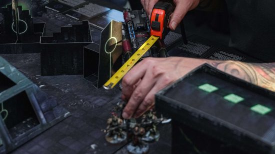 Warhammer MMO development team Jackalyptic play Warhammer at an off-site event - closeup of hands moving Custodes miniatures