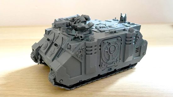 Building Warhammer 40k with fake nails - author photo showing an assembled Adepta Sororitas Rhino model, unpainted, in grey plastic, sitting on a desk