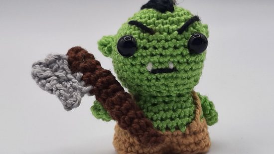 crochet DnD mini of a half orc barbarian.