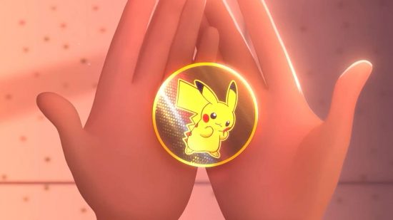 Pokemon TCG anime Path to the Peak - a pair of hands hold a golden Pikachu badge