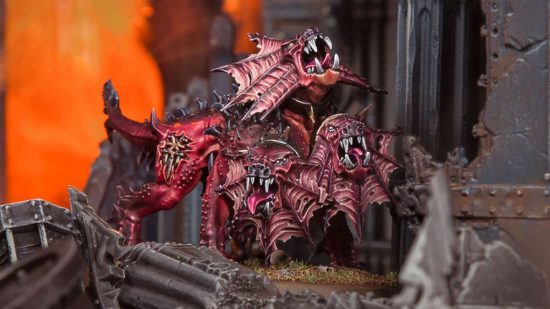Warhammer 40k: Battlesector DLC: Daemons of Khorne - a Games Workshop photo of a Fleshhound of Khorne model, a redskinned wolf daemon with three heads, each with neck frills