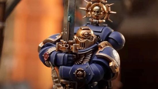 Warhammer 40k Space Marine Champion - a power-armored Space Marine with a golden helm wields a two handed blade in a guard stance.