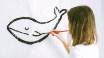 Pictionary words - a girl painting a whale on a wall.