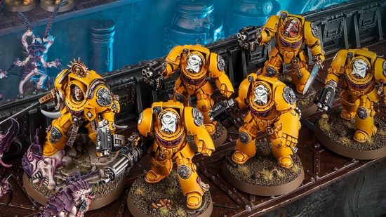 A squad of yellow-armored Imperial Fists Space Marine terminators, led by a Terminator Captain