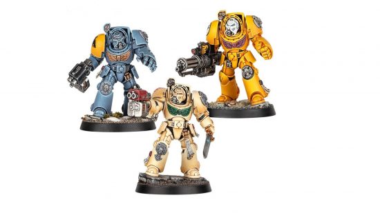 Three Space Marine Terminators, heavily armored warriors in the blue-grey livery of the Space Wolves, bone-white livery of the Deathwing, and Yellow livery of the Imperial Fists
