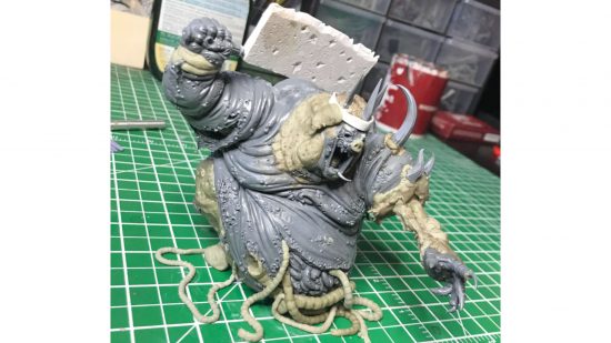 Warhammer Nurgle Great Unclean One converted into the Swine Prince from Darkest Dungeon, a bloated,, legless, pig-faced monster with a cleaver, writhing on its own intestines