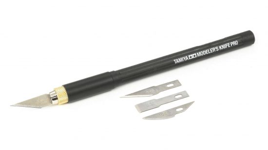 Best hobby knife - Tamiya modeler's knife pro, a black hobby knife pictured beside three spare blades